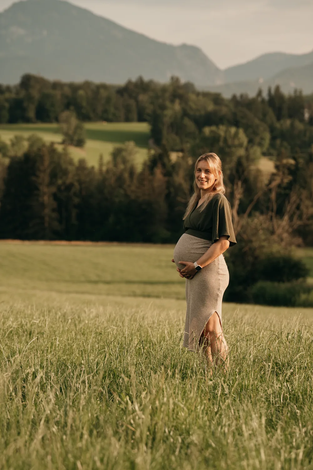 Schwangere Frau im Feld am Chiemsee im Abendlicht