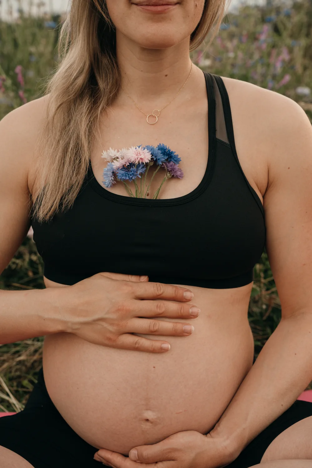 Babybauch mit Kornblumen – Detailaufnahme im Chiemgau