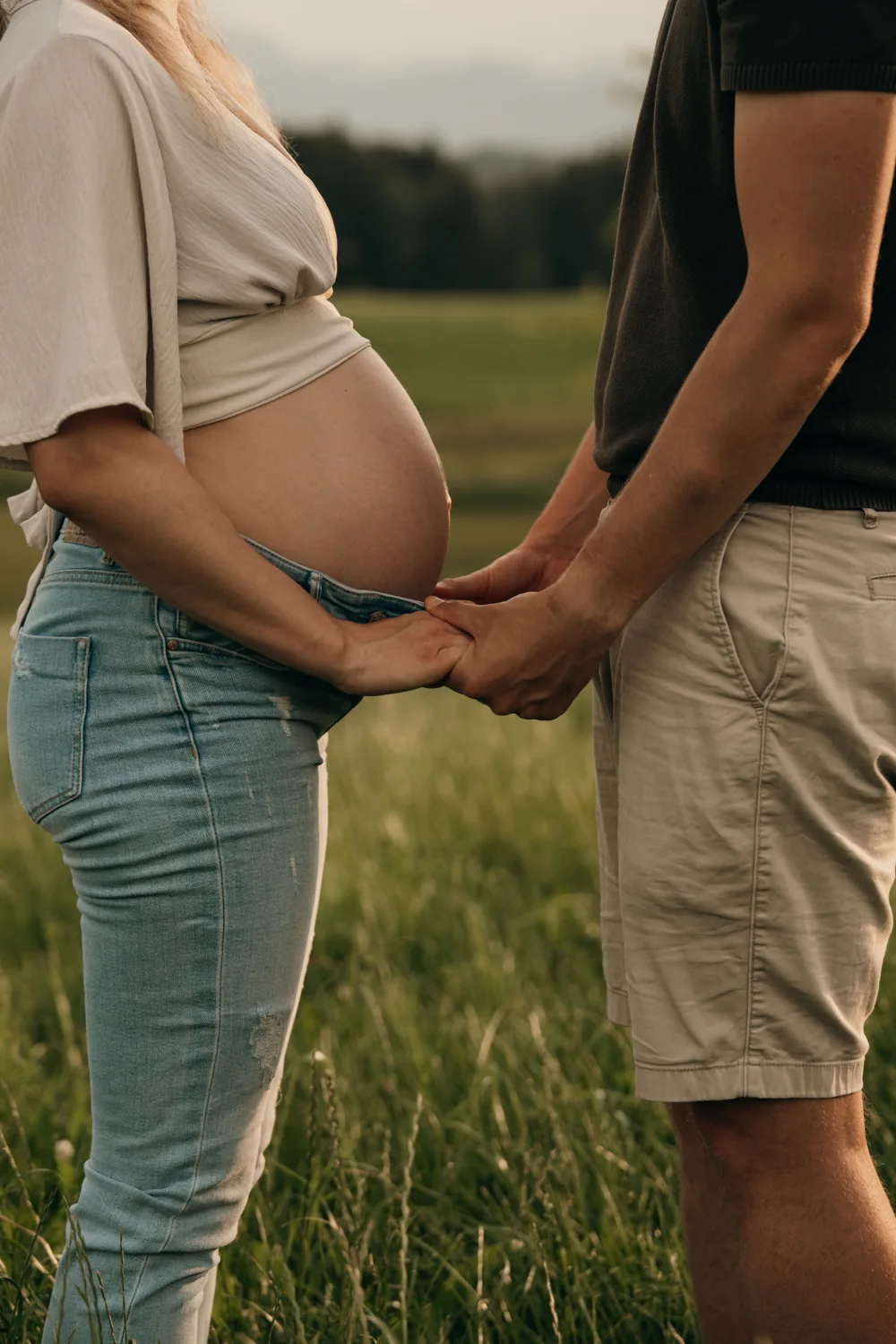 Hände der werdenden Eltern auf dem Babybauch
