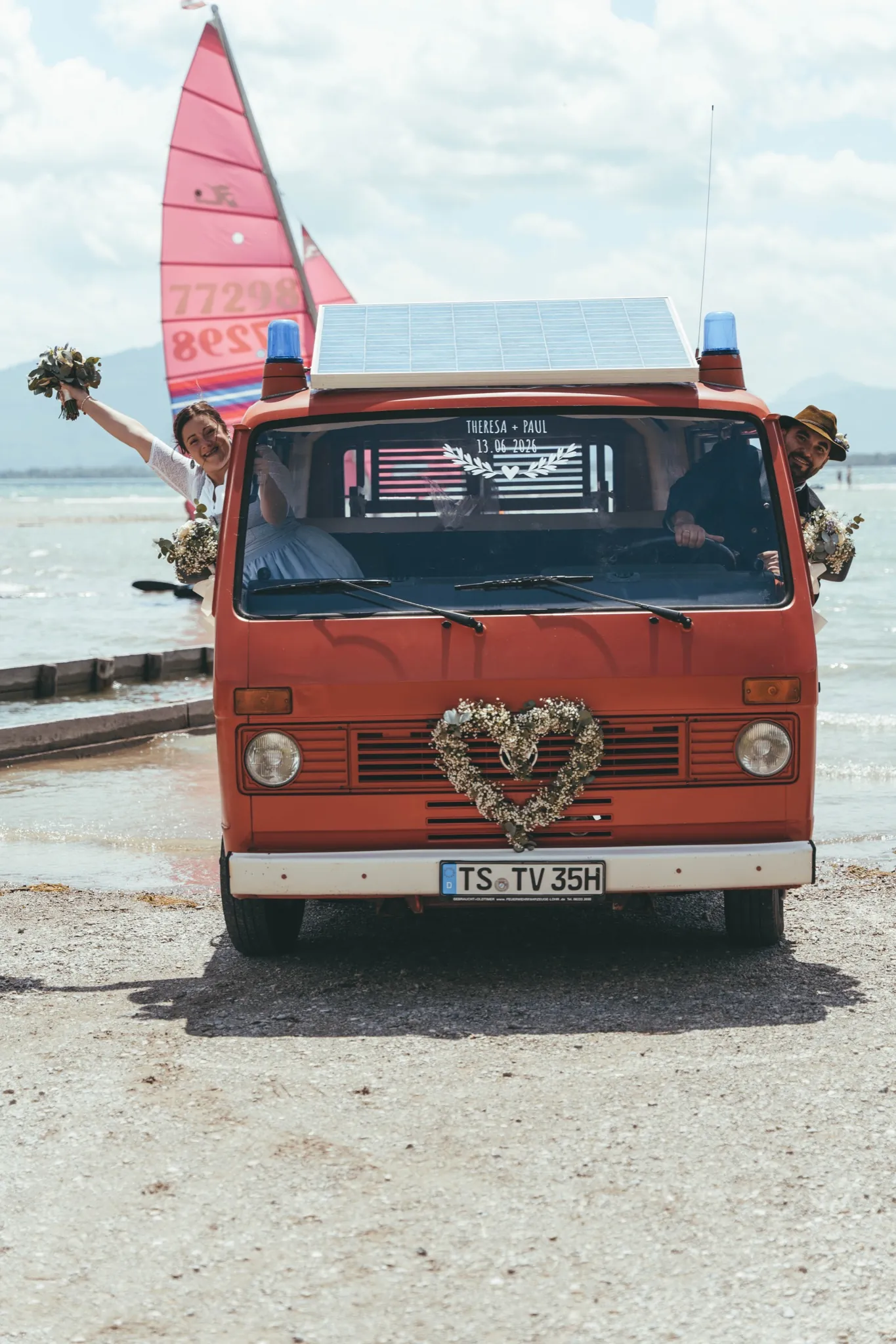 Brautpaar im roten Oldtimer-Bulli am Chiemsee