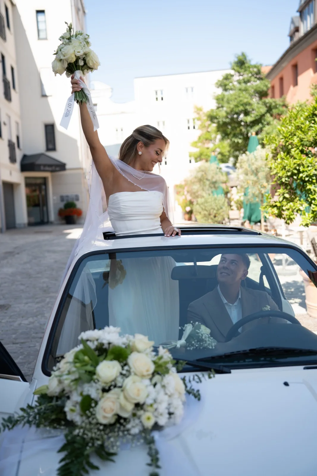 Braut jubelt aus dem Schiebedach des Hochzeitsautos – fertige Bildbearbeitung
